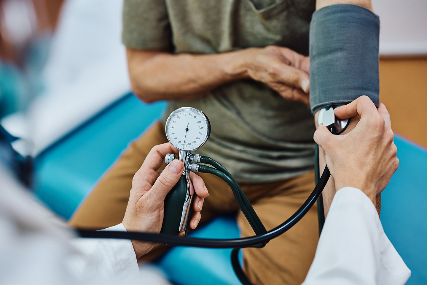 Close up of senior man getting his blood pressure checked during medical examination in the hospital.